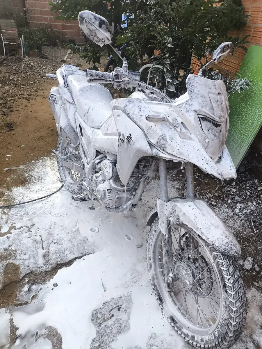 Moto totalmente coberta por espuma branca após aplicação com o pulverizador
